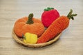 Cute knitted vegetables toys on a wicker plate