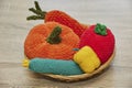 Cute knitted vegetables toys on a wicker plate