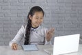 Cute korean teenage girl at school waving hand looking at laptop