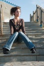 Cute lady in casual clothes sitting on stairs