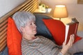 Cute lady reading a novel in bed Royalty Free Stock Photo