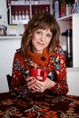 Cute lady with red mug alone in a cafe