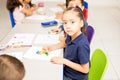 Cute Latin girl coloring in a classroom Royalty Free Stock Photo