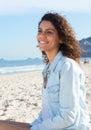 Cute latin woman with curly hair dreaming at beach