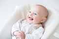 Cute laughing baby boy sitting in a high chair