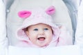 Cute laughing baby girl enjoying a stroller ride