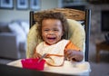 Laughing Child sitting in his high chair eating a meal Royalty Free Stock Photo