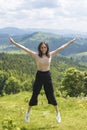 Cute laughing girl is jumping against the backdrop of mountains Royalty Free Stock Photo