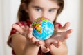 Cute lgirl holding little World Globe on her Hands Royalty Free Stock Photo