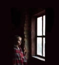 Girl at the window on a black background Royalty Free Stock Photo