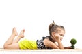 Cute litthe girl lying on the ground and playing with tiny little toy tree