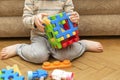 Cute little adorable caucasian boy playing with multi-colored constructor at home. Babys hands building tower of plastic blocks. Royalty Free Stock Photo