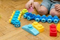 Cute little adorable caucasian boy playing with multi-colored constructor at home. Babys hands building tower of plastic Royalty Free Stock Photo