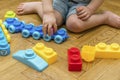 Cute little adorable caucasian boy playing with multi-colored constructor at home. Babys hands building tower of plastic Royalty Free Stock Photo