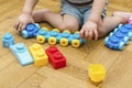 Cute little adorable caucasian boy playing with multi-colored constructor at home. Babys hands building tower of plastic Royalty Free Stock Photo