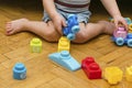 Cute little adorable caucasian boy playing with multi-colored constructor at home. Babys hands building tower of plastic Royalty Free Stock Photo