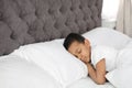 Cute little African-American boy sleeping in bed. Royalty Free Stock Photo