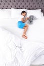 Cute little African-American boy with toy rabbit sleeping in bed, top view Royalty Free Stock Photo