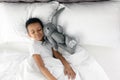 Cute little African-American boy with toy rabbit sleeping in bed Royalty Free Stock Photo