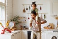 Cute little african american child son sitting on father shoulders while playing together at home Royalty Free Stock Photo