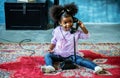 Cute little african american girl playing with vintage old dial phone on the carpet, Bonding time, educational playtime Royalty Free Stock Photo