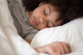 Cute little african american kid girl sleeping alone in bed Royalty Free Stock Photo