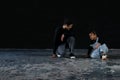 Cute little African kid boy and cool young Asian man teacher with tattoo are practice hip hop or freestyle dancing on cement floor Royalty Free Stock Photo