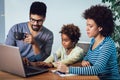 Cute little Afro-American girl and her beautiful young parents using a laptop and doing shopping online Royalty Free Stock Photo