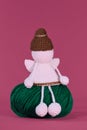 Cute little angel crocheted, handmade art. Amigurumi one white angel without face wears brown hat, sits on green ball of Royalty Free Stock Photo
