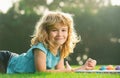 Cute little artist boy. Child boy enjoying art and craft drawing in backyard or spring park. Children drawing draw with Royalty Free Stock Photo