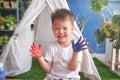 Cute little Asian boy child finger painting with hands and watercolors at home, Creative play for kids and toddlers concept