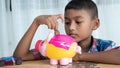 Little asian boy with piggy bank