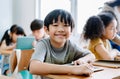 Cute little Asian boy smiling looking at camera and using laptop in computer class at the elementary school. Education, school, Royalty Free Stock Photo