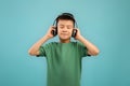 Cute Little Asian Boy Wearing Wireless Headphones Listening Music With Closed Eyes Royalty Free Stock Photo