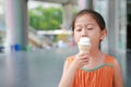 Cute little Asian child girl enjoy eating ice cream cone Royalty Free Stock Photo