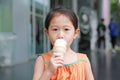 Cute little Asian child girl enjoy eating ice cream cone Royalty Free Stock Photo