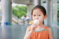 Cute little Asian child girl enjoy eating ice cream cone Royalty Free Stock Photo