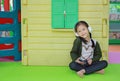 Cute little Asian child girl listening music by headphone near toy playhouse in playground Royalty Free Stock Photo