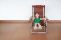 Cute little Asian child girl lying on Thai wooden traditional chair