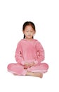 Cute little asian child girl in pink tracksuit with eyes closed practicing mindfulness meditation sitting on white background. Royalty Free Stock Photo