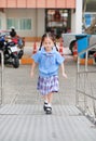 Cute little Asian child girl in school uniform running up metal stair Royalty Free Stock Photo