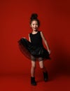 Cute little asian girl ballerina in beautiful black dress is dancing happy smiling on red full body Royalty Free Stock Photo