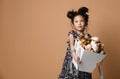 Cute little asian girl in beautiful spring dress holds a big basket of big white flowers pion and looks up at somebody