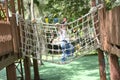 Cute little Asian girl climbing rope net and playing at the playground. Royalty Free Stock Photo