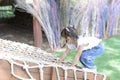 Cute little Asian girl climbing rope net and playing at the playground. Royalty Free Stock Photo