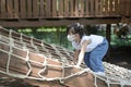 Cute little Asian girl climbing rope net and playing at the playground. Royalty Free Stock Photo