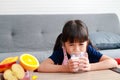 Cute little Asian girl drinking milk. Children are forced to drink milk.