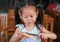 Cute little Asian girl eating bread sheet. Asian girl having breakfast Royalty Free Stock Photo