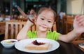 Cute little Asian girl eating bread sheet. Asian girl having breakfast Royalty Free Stock Photo