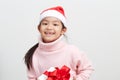 Girl holding a gift box in sweater and santa hat Royalty Free Stock Photo